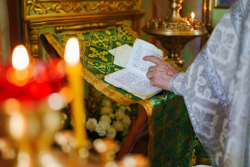 A priest with a prayer book on a table conducts the service. 