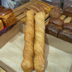 A vibrant display of freshly baked breads for sale, featuring homemade loaves, flaky croissants, and assorted flatbreads, inviting customers to indulge in delicious, artisanal flavors.