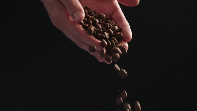 Slow motion mam pour coffee beans over balck background