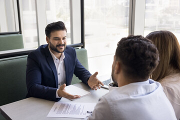 Sales manager and clients discussing term of agreement met in company office. Couple purchasing...