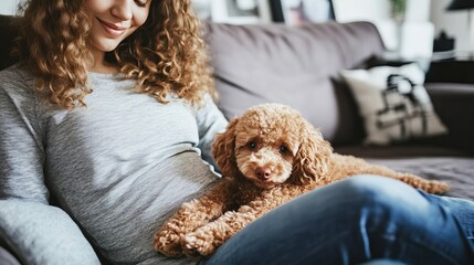 Young pregnant woman sitting on a cozy sofa at home, gently holding her belly while relaxing with her pet dog. Concept of motherhood, family bonding, pregnancy comfort, and pet companionship