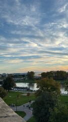 Obraz premium “Warm sunset view from Krakow castle overlooking river, buildings and calm nature.”