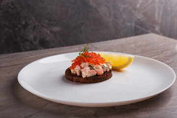 Toast skagen - classic Swedish appetizer. Sandwich with shrimps and caviar on dark table. Isometric style. Nordic cuisine.