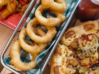A variety of food such as pizza and fried onions Top view. Panorama with