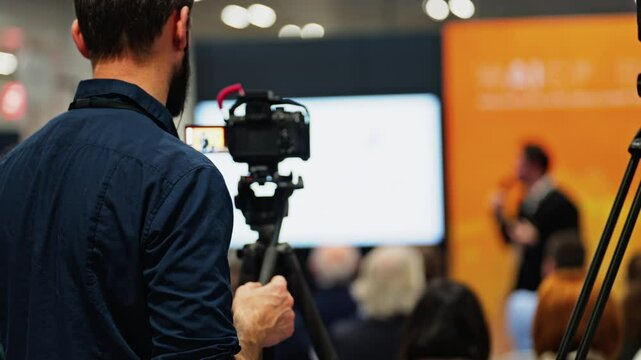 Man filming with a professional camera at a conference
