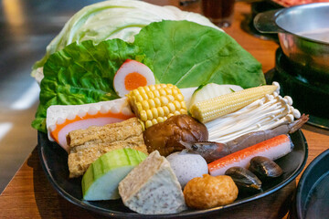 A steaming hot pot feast brings together fresh ingredients and rich flavors in a warm, communal dining experience. The bubbling broth, infused with aromatic spices, serves as the perfect base for cook