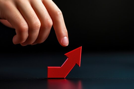 A person's hand extends to grab a bright red arrow, highlighting the importance of focus and attention