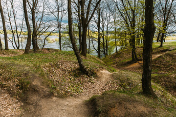 Obraz premium Ruined Line Of Defense. Memory Of War. Old Abandoned World War Ii Trenches At Riverside Since Second World War. Early Spring Season. Cloudy Blue Sky. Old Infantry Fortifications