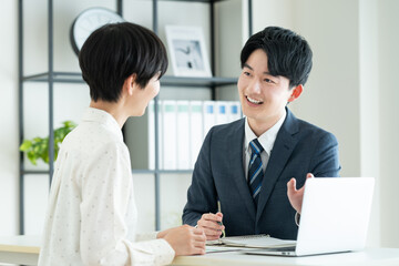 Obraz premium 若い女性に提案するビジネスマン