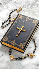 Black prayer book with gold crucifix and rosary beads on marble