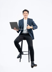 Full body image of young Asian business man using laptop and sitting in chair on white background	