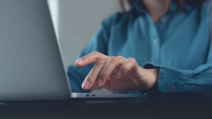 Businesswoman working on laptop computer on table at office, close up. Business woman busy working,...
