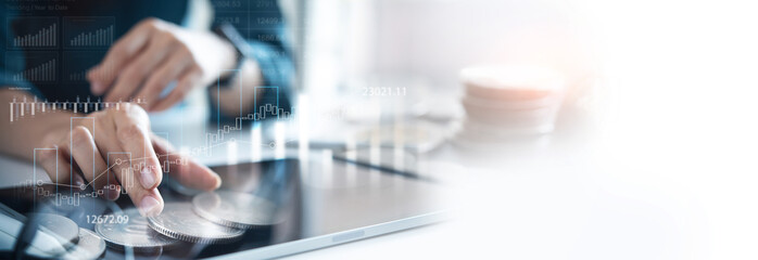Business, finance and investment concept. Businessman working on digital tablet with financial graph report, business data analysis, double exposure with coins for finance investment background