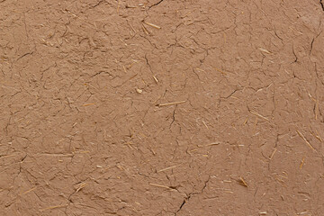 Textured background of wall of clay with straw. Adobe wall. Clay and straw are popular building...