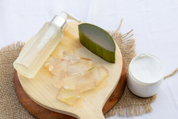 Fresh aloe vera leaves and slices arranged elegantly to highlight their soothing and hydrating...