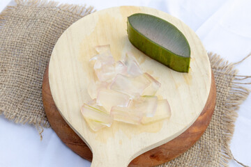 Fresh aloe vera leaves and slices arranged elegantly to highlight their soothing and hydrating...