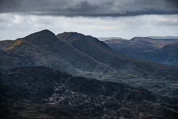 The landscape is rugged. Steep mountains and deep valleys, surrounded by ominous clouds that hint...