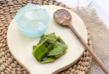 Fresh aloe vera leaves and slices arranged elegantly to highlight their soothing and hydrating...