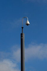Closed Circuit Video Surveillance cameras on pole  against blue sky