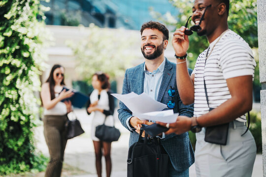 A diverse group of business people engaged in an outdoor meeting, exchanging ideas and strategies for growth. They are brainstorming and analyzing revenue and sales opportunities in a vibrant city