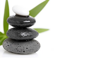 Fototapeta premium Stack of wet zen stones balancing with green leaves on white background