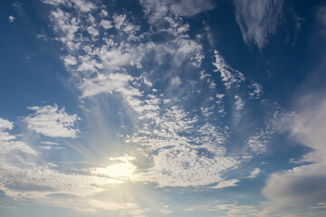 Blue sky with stratocumulus and cirrus clouds backlit