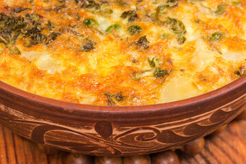 Prepared potato casserole in clay bowl, fragment close-up