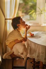 A boy eats strawberries at the table