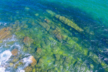 rocky coast with turquoise and transparent waters, background for summer and vacations. Aerial...
