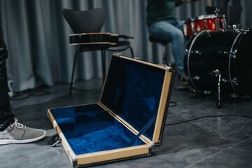 Musicians Rehearsing in Studio With Guitar Case and Drum Set