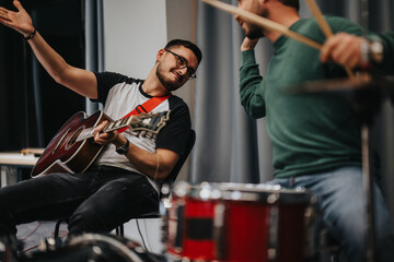 Two musicians create music together in a studio setting, showcasing teamwork and creativity. The joyful moment captures the unique energy and connection while playing instruments including an acoustic