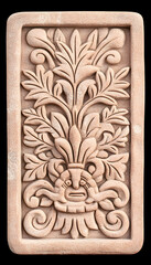 Intricate floral relief carving with central grotesque mask, light terracotta color