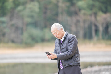 A bamboo forest pond on a spring noon day in Japan with a lot of greenery. A Japanese man in his...