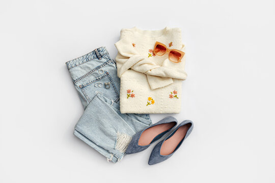 Fashion spring outfit. White jumper with blue jeans and ballet shoes. Women's stylish and elegant clothes with accessory and jewelry. Fashionable look. Flat lay, top view, overhead.