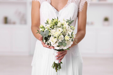 Bride with beautiful wedding bouquet on light background, closeup