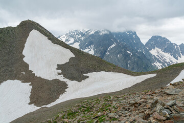 Mountain Landscape Featuring Snowy Peaks and Rocky Terrain During a Cloudy Day