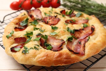 Delicious focaccia bread with bacon and parsley on white wooden table, closeup