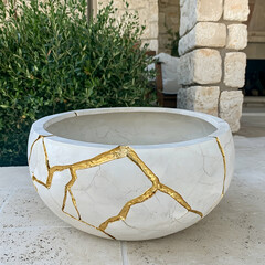 White gold-veined cracked bowl planter outdoors on patio.  Use Home decor, garden design
