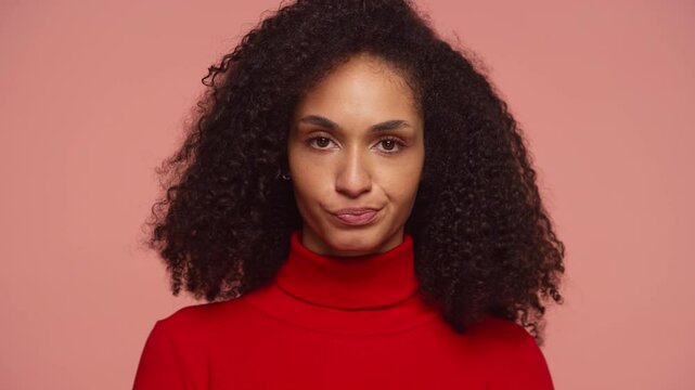 Woman shaking head in disapproval with unimpressed expression on pink