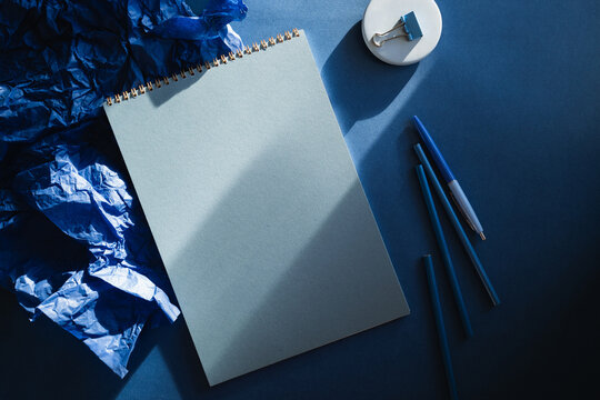 Overhead view of assorted stationery on a blue background