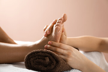 Woman receiving foot massage in spa salon, closeup