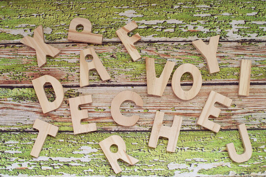 Overhead view of assorted wooden letters on a  weathered wooden table