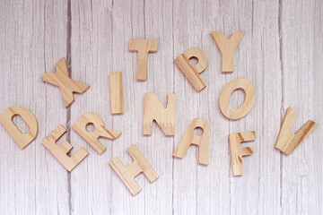 Overhead view of assorted wooden letters on a  wooden table