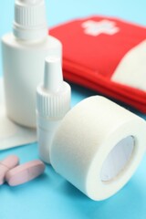 First aid kit on light blue background, closeup
