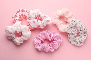 Different hair scrunchies on pink background, flat lay