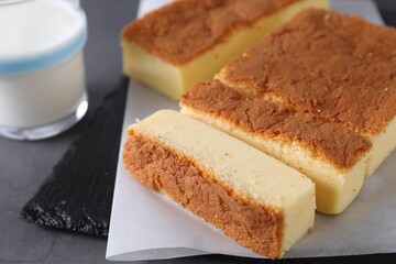 Tasty Japanese Castella sponge cake and milk on grey table, closeup