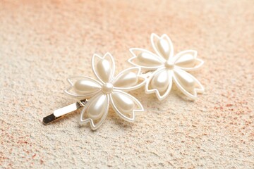 Beautiful hair clip on color textured table, closeup
