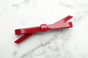 Beautiful hair clip on white marble table, top view