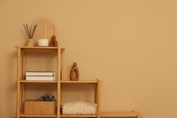 Obraz premium Shelving unit with decor near beige wall indoors, space for text