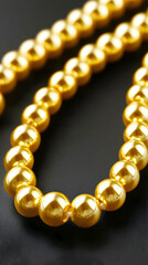 Golden pearl necklace on black background; luxury jewelry, fashion accessory